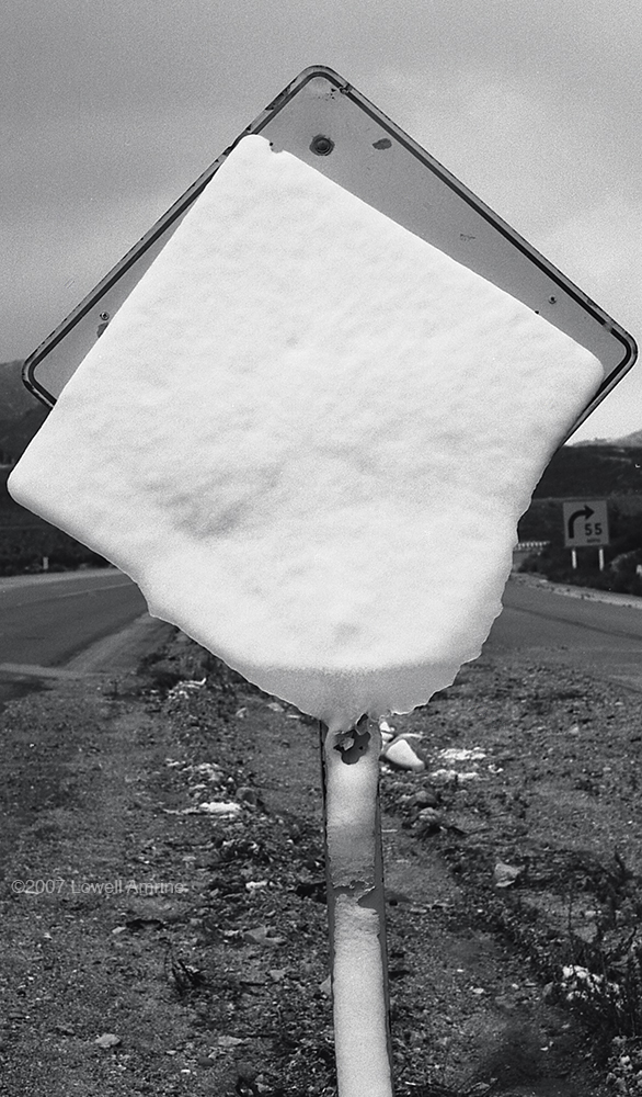 Ice and snow sliding off a highway sign on Cajon Pass